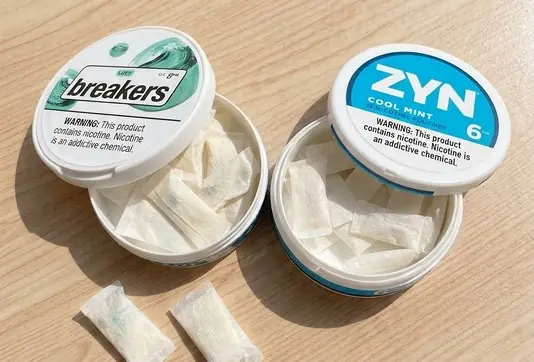 Open LUCY Breakers and ZYN Cool Mint cans with pouches on a wood table